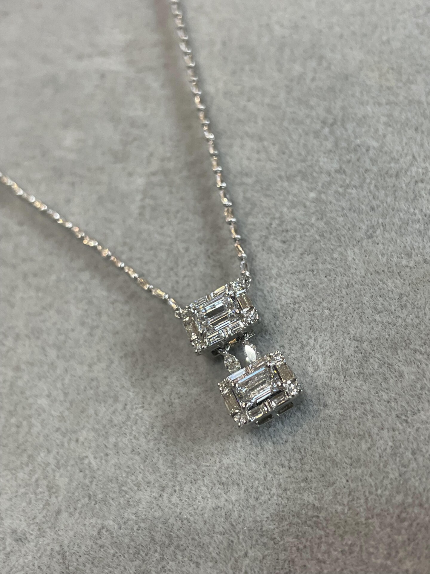 0.5キャラットのエメラルドカットのダイヤモンドを小さなダイヤモンドで取り囲んだデザインのネックレス