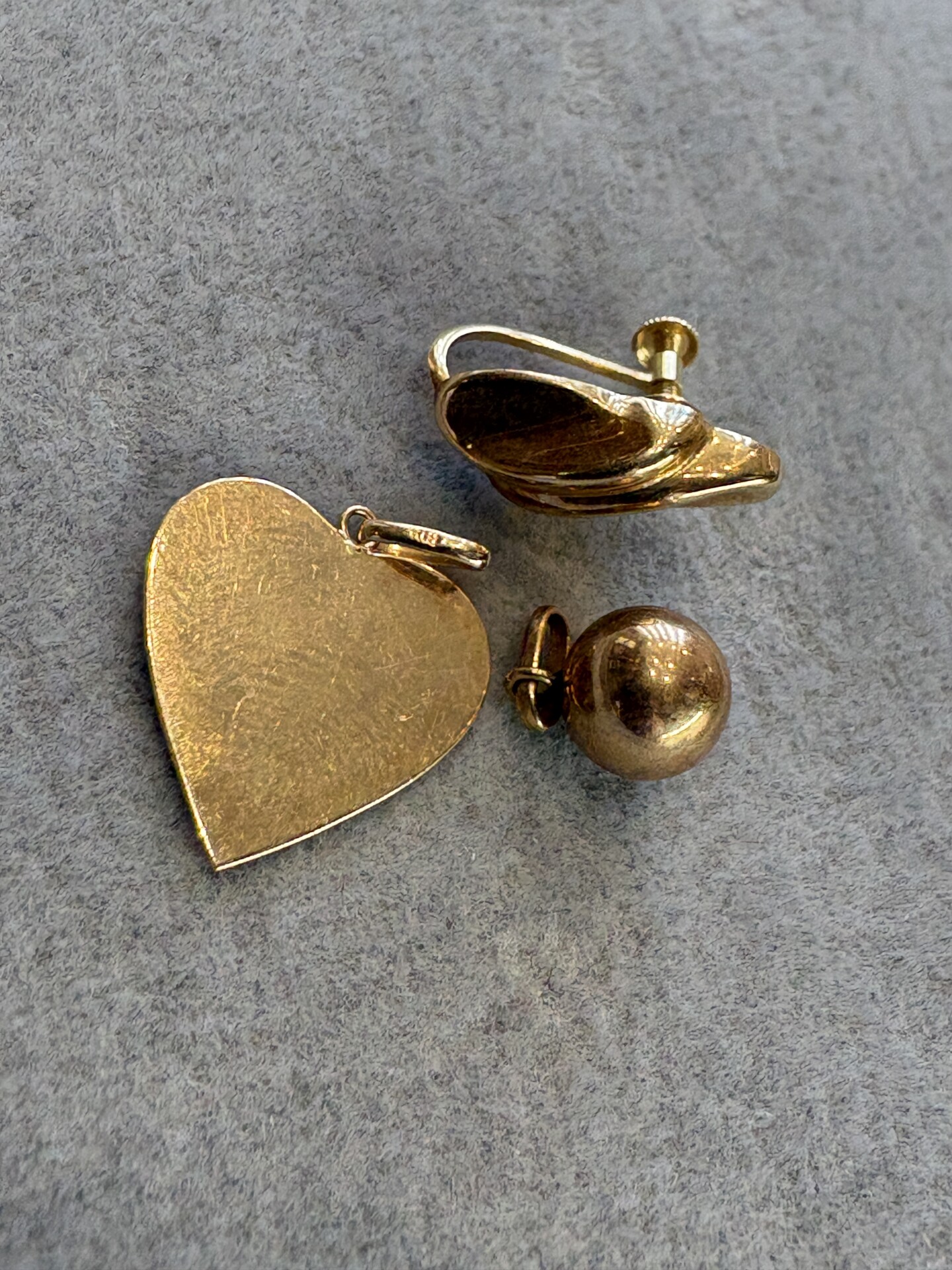 Pingentes pequenos de ouro 750 ou ouro 18K, brincos avulsos e outros itens.